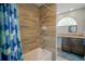 Bathroom view of shower and tub combo with tiled walls, window, and vanity at 5490 Se Highway 42, Summerfield, FL 34491