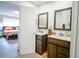 Bathroom featuring dual sink vanity with wood cabinets and framed mirrors at 5490 Se Highway 42, Summerfield, FL 34491