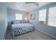 Comfortable bedroom with light blue walls, wood look floors and ample natural light, creating a relaxing space at 5490 Se Highway 42, Summerfield, FL 34491