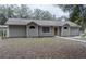 Charming single-story home with a light brown exterior, sidewalk and treed front lawn at 5490 Se Highway 42, Summerfield, FL 34491