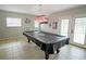 Recreation room featuring a pool table and patio doors leading to the outdoor pool at 5490 Se Highway 42, Summerfield, FL 34491