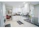 Modern kitchen featuring white cabinetry, marble countertops, stainless steel appliances, and an open view to the living room at 5490 Se Highway 42, Summerfield, FL 34491