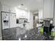 Bright kitchen featuring sleek marble countertops, white cabinetry, stainless appliances, and modern fixtures at 5490 Se Highway 42, Summerfield, FL 34491