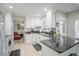 Modern kitchen with white cabinetry, stainless steel appliances, and black marble countertops at 5490 Se Highway 42, Summerfield, FL 34491