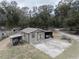 View of a small outbuilding with attached carport on a large, treed lot at 5490 Se Highway 42, Summerfield, FL 34491