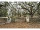 Gated property entrance with aged stone pillars and lush tree coverage at 5490 Se Highway 42, Summerfield, FL 34491