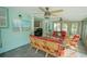 Inviting sunroom featuring wicker furniture, ceiling fans, and tranquil views of the home's exterior at 5490 Se Highway 42, Summerfield, FL 34491