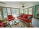 Bright sunroom with rattan seating, ceiling fan, and views of the pool and outdoor space at 5490 Se Highway 42, Summerfield, FL 34491