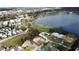 Aerial view of a property near a lake, surrounded by lush greenery and featuring a well-maintained yard and nearby homes at 5812 Luzon Pl, Orlando, FL 32839