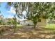 Expansive backyard with mature trees, a patio with seating, and plenty of green space at 5812 Luzon Pl, Orlando, FL 32839