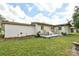 View of the backyard with a patio seating area, green lawn and the home's exterior at 5812 Luzon Pl, Orlando, FL 32839