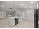 Open kitchen with a central island, sleek black dishwasher, and modern pendant lighting fixtures at 6 Dogwood Loop Ave, Ocala, FL 34472