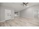 Bright living room with wood-look flooring, a ceiling fan, and a front door leading to the outdoors at 6 Dogwood Loop Ave, Ocala, FL 34472