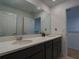 Bathroom with a double sink vanity, large mirror, and neutral paint at 6320 Sw 74Th Terrace Rd, Ocala, FL 34474