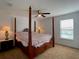 Bedroom with a four-poster bed, ceiling fan, side tables, and a bright window at 6320 Sw 74Th Terrace Rd, Ocala, FL 34474