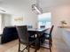 Dining area with a dark wood table, leather chairs, modern light fixture, and a view into the living room at 6320 Sw 74Th Terrace Rd, Ocala, FL 34474