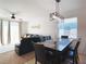 Dining area with a dark wood table, leather chairs, modern light fixture, and a view into the living room at 6320 Sw 74Th Terrace Rd, Ocala, FL 34474