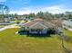 An aerial view of a charming home with a cozy front porch in a quiet neighborhood surrounded by lush trees at 7398 Hemlock Rd, Ocala, FL 34472