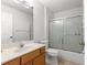 Bathroom featuring a tub with sliding glass doors, a vanity with marble countertop, and a tiled floor at 7398 Hemlock Rd, Ocala, FL 34472