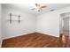 Bedroom with hardwood floors, a ceiling fan, and an open doorway at 7398 Hemlock Rd, Ocala, FL 34472