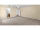 Spacious carpeted bedroom with ceiling fan, and adjacent bathroom at 7398 Hemlock Rd, Ocala, FL 34472