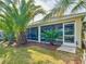 Lush backyard featuring tropical landscaping and a screened-in porch area with a well-manicured lawn at 805 Pickett Rd, The Villages, FL 32163