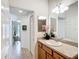 Bright bathroom featuring a granite countertop, warm wood cabinets, and decorative flower arrangement at 805 Pickett Rd, The Villages, FL 32163