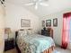 Comfortable bedroom featuring a floral-patterned bedspread, side tables, and natural light at 805 Pickett Rd, The Villages, FL 32163