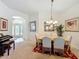 Dining room featuring chandelier lighting, seating for six, and views into the foyer at 805 Pickett Rd, The Villages, FL 32163