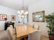 Dining room area featuring chandelier lighting, seating for six, and a decorative mirror at 805 Pickett Rd, The Villages, FL 32163