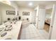 Well-lit bathroom featuring dual sinks, a soaking tub, and white tiled flooring at 8585 Nw 162Nd Ct, Morriston, FL 32668