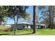 Exterior view of home and attached garage, showcasing its white stucco, metal roof, and landscaping at 8585 Nw 162Nd Ct, Morriston, FL 32668