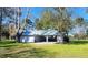 Exterior view of a home with attached garage, offering ample parking and additional storage space on a well-manicured lawn at 8585 Nw 162Nd Ct, Morriston, FL 32668