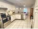 Well-lit kitchen featuring white cabinets, stainless steel appliances, and a cozy dining area at 8585 Nw 162Nd Ct, Morriston, FL 32668