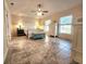 Bright main bedroom with tile flooring, ceiling fan, and a bench at the foot of the bed at 8585 Nw 162Nd Ct, Morriston, FL 32668