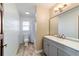 Bright bathroom with white shiplap walls, wood-look flooring, and a grey vanity at 8947 Se 70Th Ter, Ocala, FL 34472