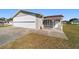 Exterior view showcasing the property's driveway, well-maintained lawn, and inviting front porch at 8947 Se 70Th Ter, Ocala, FL 34472