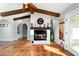 Living room with wooden beams, a brick fireplace, and tile flooring leading to other rooms at 8947 Se 70Th Ter, Ocala, FL 34472