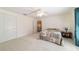 Bright bedroom features neutral carpet, ceiling fan, and natural light from window, plus a view of the hallway at 905 Se 12Th St, Ocala, FL 34471