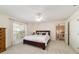 Bright bedroom features neutral carpet, ceiling fan, and natural light from the window with light curtains at 905 Se 12Th St, Ocala, FL 34471