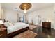 Bright main bedroom with a decorative ceiling medallion, dark wood floors, and double doors at 905 Se 12Th St, Ocala, FL 34471