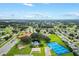 Aerial view of a community showcasing mature trees, lawn, amenities, and residential buildings in the distance at 9493 Se 173Rd Ln, Summerfield, FL 34491