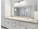 Bathroom featuring a double sink vanity and large mirror, complemented by bright vanity lighting at 9493 Se 173Rd Ln, Summerfield, FL 34491