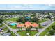 Beautiful aerial view of the community clubhouse, pool, tennis court, and surrounding neighborhood at 9493 Se 173Rd Ln, Summerfield, FL 34491