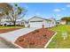 Side view of a charming single-story home with well-manicured landscaping and a concrete driveway at 9493 Se 173Rd Ln, Summerfield, FL 34491