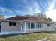 Back exterior featuring a screened-in lanai, a concrete patio, and a well-maintained lawn at 9681 Sw 97Th Ln, Ocala, FL 34481