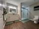 Modern bathroom with a double vanity, marble-tiled shower, and wood-look flooring at 9681 Sw 97Th Ln, Ocala, FL 34481