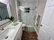 Bright bathroom features a marble-tiled shower with glass door, modern vanity, and wood-look flooring at 9681 Sw 97Th Ln, Ocala, FL 34481