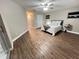 Large bedroom featuring wood-look floors, ceiling fan, windows, and a comfortable bed at 9681 Sw 97Th Ln, Ocala, FL 34481