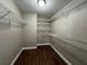 Walk-in closet with wood-look flooring and metal shelving for ample storage at 9681 Sw 97Th Ln, Ocala, FL 34481